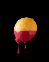 Lemon with paint dripping on a black background Isolated