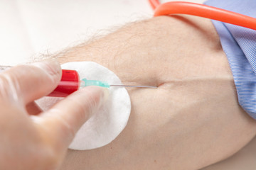 Female hands in transparent latex medical gloves are taking venous blood from a patient. Taking venous blood from a patient. Side view. Closeup.