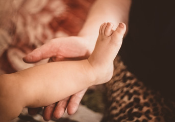 The old woman's hand touches the child's leg