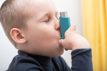 Boy with a pulmonary disease school uses an asthma inhaler