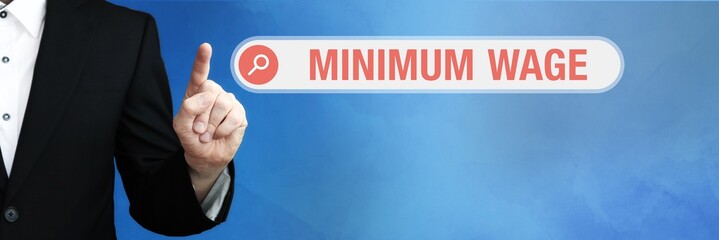 Minimum Wage. Lawyer in suit points with his finger to a search box. The term Minimum Wage is in focus. Concept for law, justice, jurisprudence