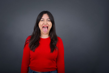 Beautiful woman doubt expression, confuse and wonder concept, uncertain future shrugging shoulders, standing against gray Wall.