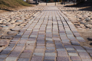 The sidewalk paved with brick blocks goes with the prospect of a distance. Comfortable straight the sidewalk