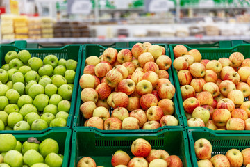 Baskets filled with green and red apples at a supermarket. Nutritious fruit. Foreground in focus.
