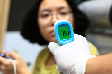 An infrared thermometer checks the body temperature. Check for human coronavirus