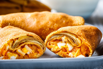 pancakes or crepes stuffed with cabbage and boiled eggs served with sour cream