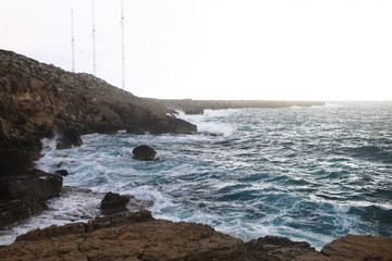 Waves hitting the rocky cliffs in a beach located in Cyprus,This weather might be dangerous for water sports but simultaneously the waves and their splashes are pretty and wild