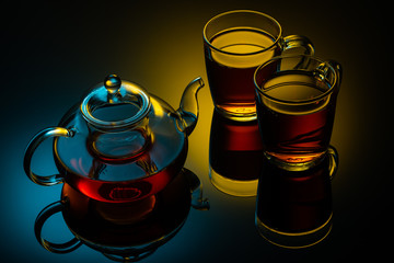 glass teapot and cups with hot tea on table, close view  