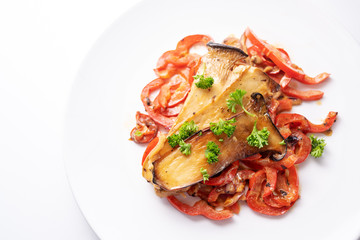 King oyster mushrooms on red bell pepper with parsley garnish served on a white plate, healthy vegetable meal for low carb diet and vegetarians, copy space, high angle view from above
