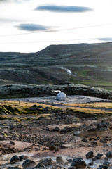 A small igloo like structure in the Icelandic highlands. Smoke is blowing from its chimney. The...