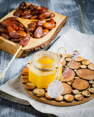 jar with organic honey and dipper on wooden background