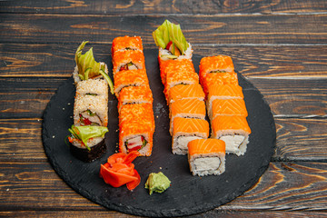 Beautiful and delicious variety of sushi rolls laid out on a stone board. - 344614864