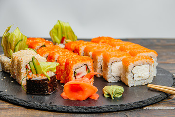 Beautiful and delicious variety of sushi rolls laid out on a stone board. - 344615053