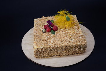 Napoleon cake with berry decoration on a black background