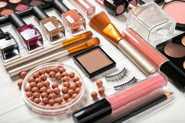 Decorative cosmetics and makeup brushes on a white background, top view