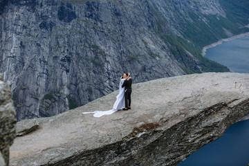 Naklejka premium Newlyweds on a rock fragment in Norway called Troll's tongue