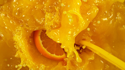 Freeze motion of pouring orange juice and falling orange slices.