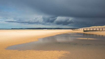 beach and sea bathed in sunshine before a storm