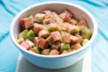 Bowl with cut rhubarb and golden sugar