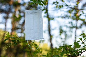 Coronavirus. Problem of ecology. Pollution of nature. Environmental protection. Medical respiratory protective face masks for coronavirus in spring are located on the bushes of flowering bird cherry