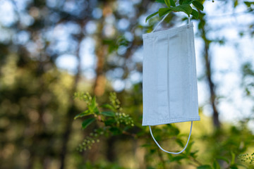 Coronavirus. Problem of ecology. Pollution of nature. Environmental protection. Medical respiratory protective face masks for coronavirus in spring are located on the bushes of flowering bird cherry