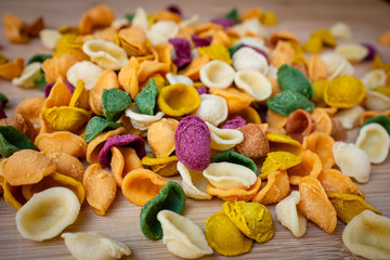 Close up of colored fresh pasta orecchiette made with vegetables and spices. Food of Puglia, Italy