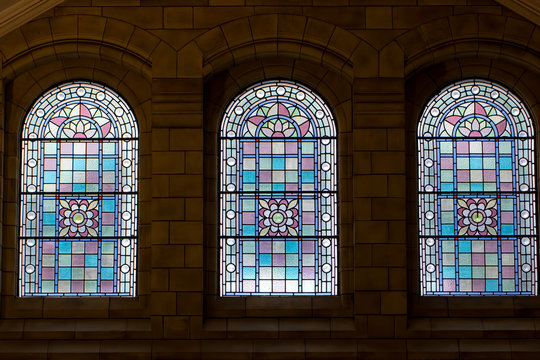Trio of stained glass windows. Three ornate purple pink windows.