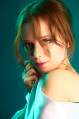 Beautiful sexy girl in a light fabric on aquamarine studio background. Studio portrait of a gentle