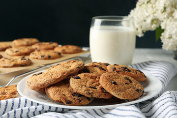 Composition with chip cookies and milk on white table