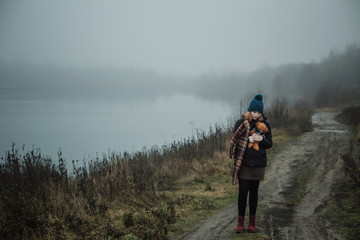 Obraz premium Sad teenager girl hugging teddy bear by foggy lake. Concept of adolescence and adolescent problems.
