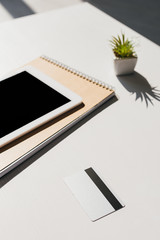 Selective focus of notepad, succulent, credit card and digital tablet with blank screen