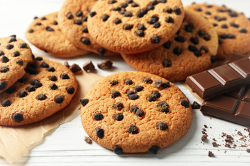 Composition with chip cookies and chocolate on white wooden background