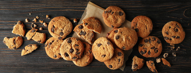 Tasty chocolate chip cookies on white wooden background