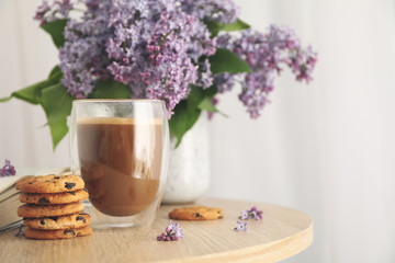 Fototapeta na wymiar Composition with chocolate chip cookies, cocoa and lilac on wooden table