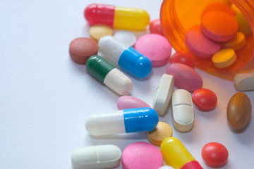 bottle of colorful pills white background 