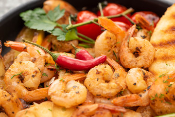 close up view of fried shrimps with grilled bread, tomatoes, chili peppers