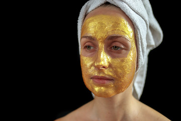 Woman face with golden hydrogel mask