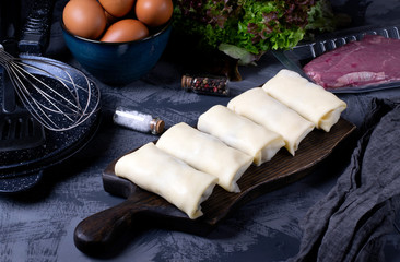 Raw rolled pancakes with filling ready to be roasted