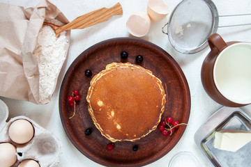 Ingredients for making dough for homemade pancakes for breakfast. On the table are wheat flour, eggs, butter, sugar, salt, milk. Selective focus. Sequencing