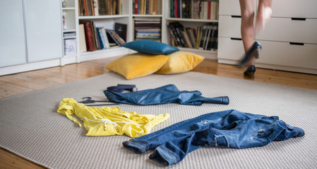 yellow and blue pieces of clothes on the floor woman undressing