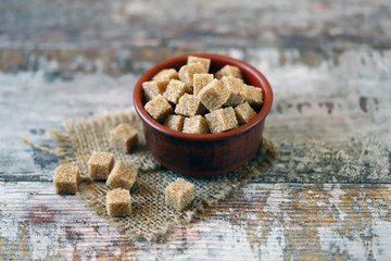 Selective focus. Macro. Brown sugar cubes. Brown sugar in a bowl. Copy space.