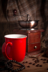 Old vintage manual coffee grinder with coffee beans on wooden background