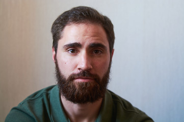 Obraz premium Portrait of young guy with dark beard with various emotions on his face in green shirt.