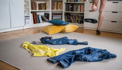 yellow and blue pieces of clothes on the floor woman undressing