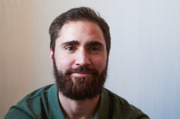 Fototapeta premium Portrait of young guy with dark beard with various emotions on his face in green shirt.