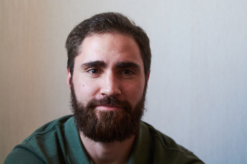 Obraz premium Portrait of young guy with dark beard with various emotions on his face in green shirt.