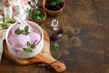 Homemade Organic Ice Cream with Mint. Blackberry ice cream in white bowl on a rustic table. Copy space.