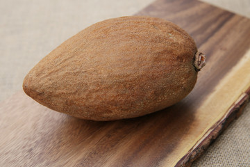 organic fresh Mamey Sapota (Pouteria sapota) or sweet plum on wooden board