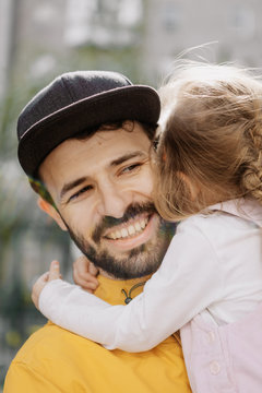 Portrait of a stylish pretty Father and his little daughter, they went for a walk on the playground in the courtyard of a multi-storey building