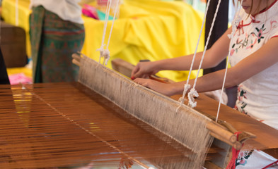 Woman weaving silk sari on loom, handmade concept.